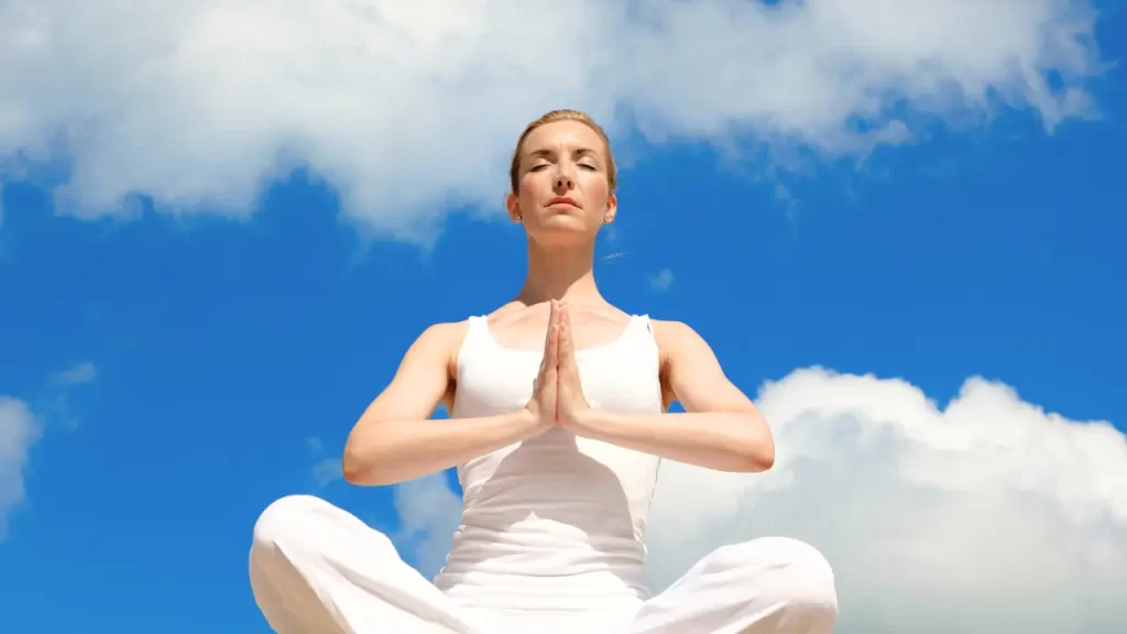 mulher ao ar livre praticando conexão com a espiritualidade através da meditação