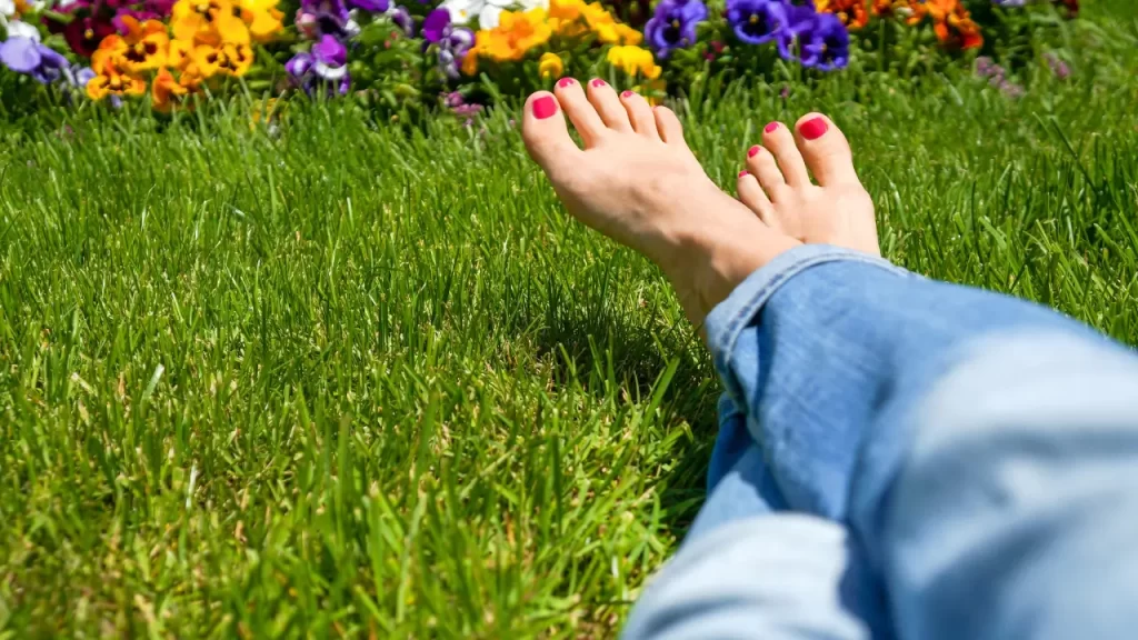 mulher com pés descalços na grama